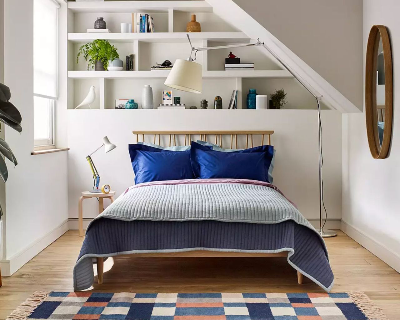 Comtemporary oak bed frame in white bedroom with wooden floors and colourful bedding