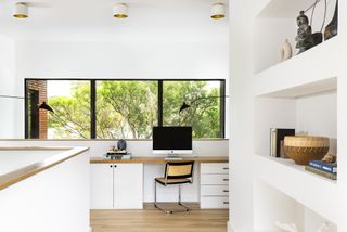 home office on mezzanine level with open shelving and built-in desk