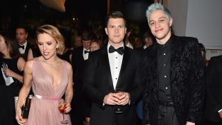 Scarlett Johansson is pretty in a light pink dress while Colin Jost rocks a bow tie and Pete Davidson sports a black coat and blue hair at an event. 