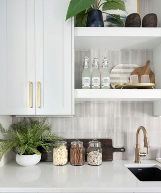 A kitchen with white textured tile backsplash