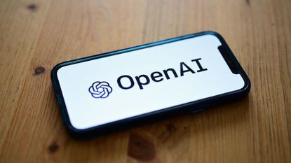 Logo of OpenAI, developer of the GPT-4.1 AI model family, pictured on a smartphone screen placed on a table.