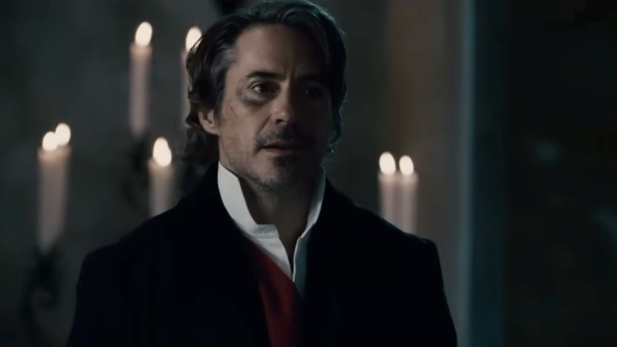 Robert Downey Jr as Sherlock Holmes with a black eye, wearing a white shirt and dark coat in Sherlock Holmes: A Game of Shadows