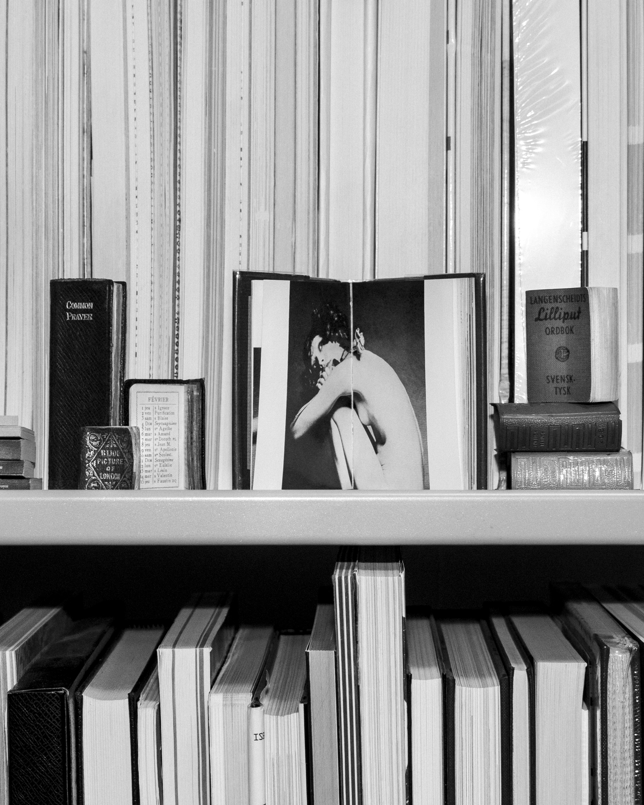 small books arranged across a shelf