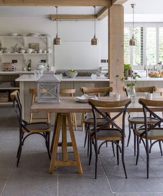Grey and white kitchen ideas with grey slate floors, an island with a white worktop, and wooden beams and columns in a farmhouse style