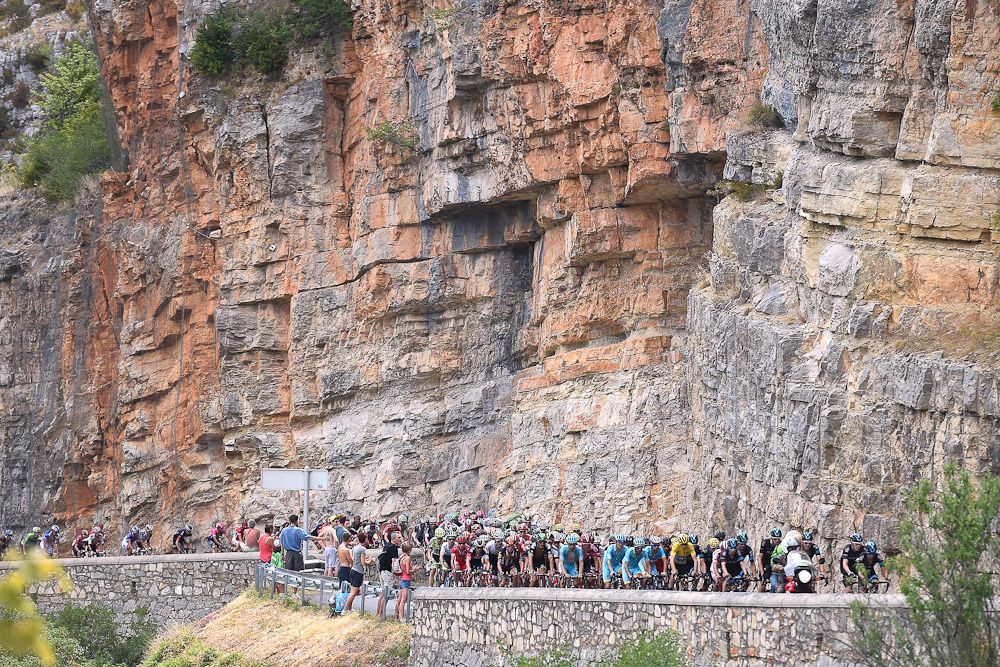 The peloton rides along a cliff edge during stage 14.
