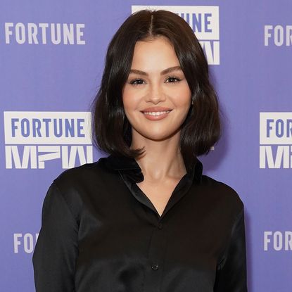 Selena Gomez wearing a black silk shirt with black pants