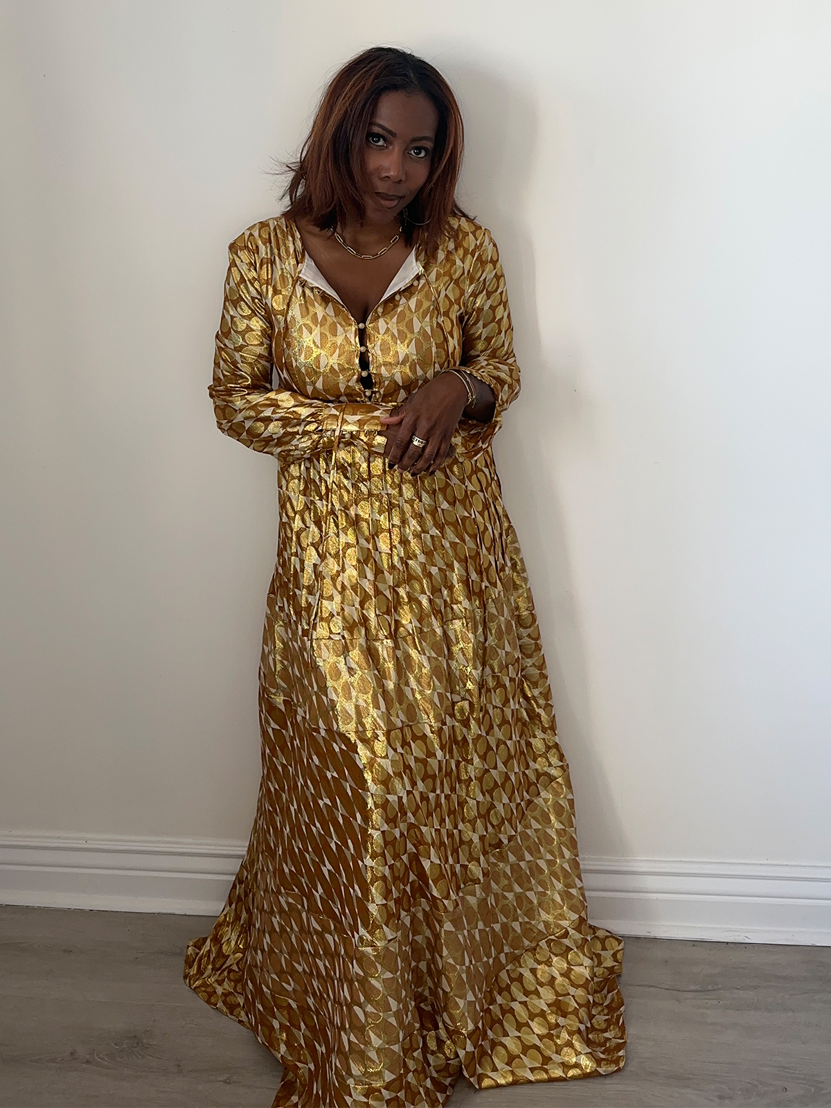 Tiffany Reid wearing a gold patterned dress from her fashion editor guide to holiday hosting.