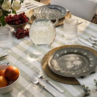 A light green and white striped tablecloth with kitchenware on top