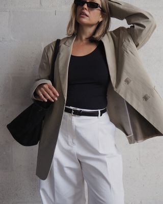 A woman wearing a blazer, vest and tailored trousers