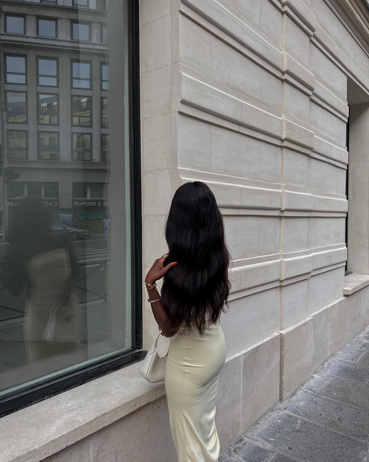Creator @aidabadji_ taking a photo outside near a shop window