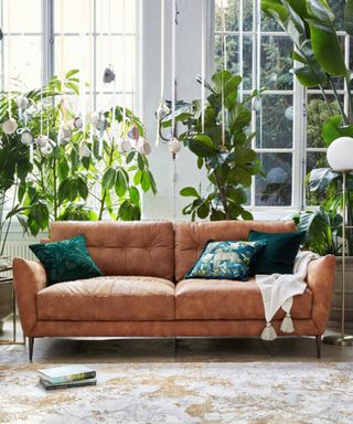 A modern living room idea with Sofology Cordelia 3 Seater in Texas Tan, £1,149, Moonshine Table Lamps, £129, Floor Lamp, £179, Cushions from £35, Furniture from £299.
