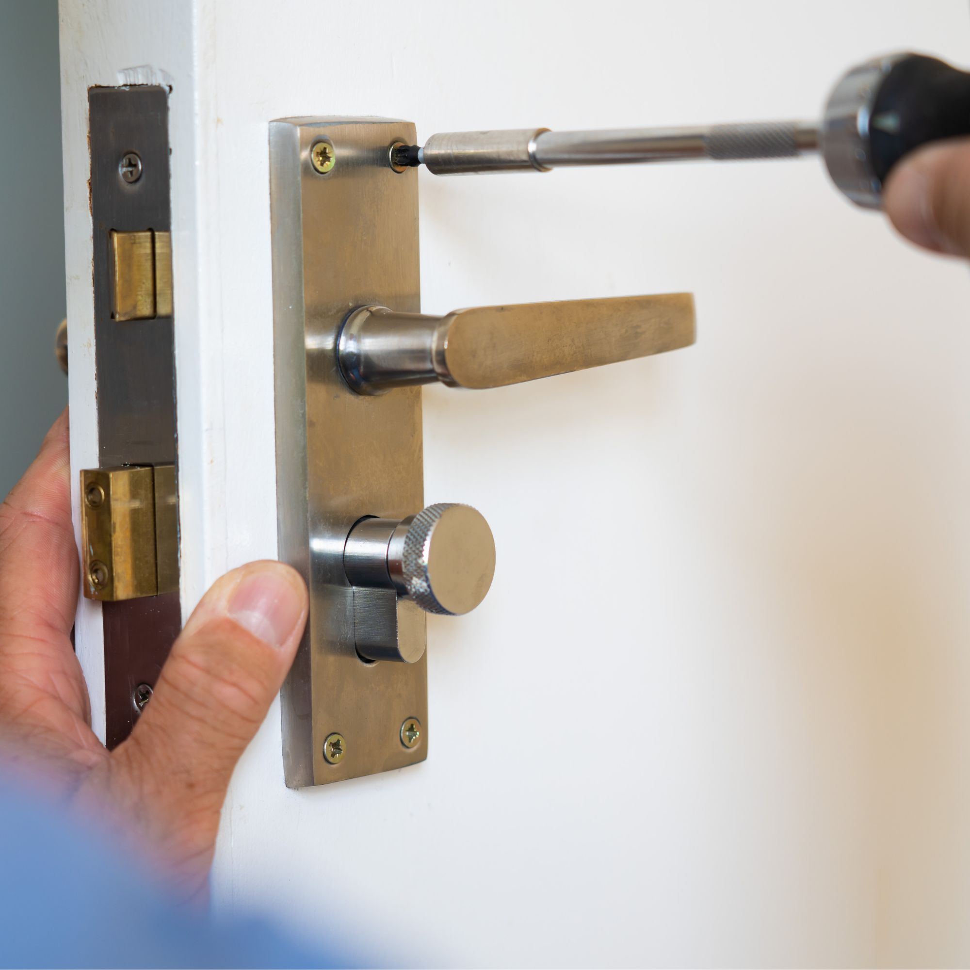 Removing an old door handle from a door with a screwdriver