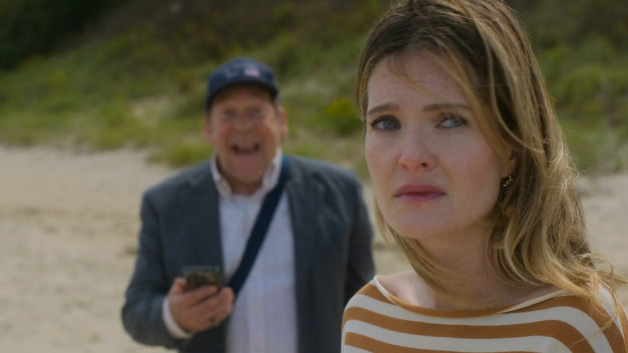 Meghann Fahy standing looking sad with Bill Camp smiling behind her in Sirens on Netflix.