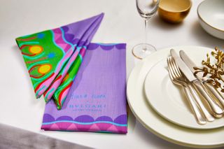Table laid with white cloth plus colourful napkins