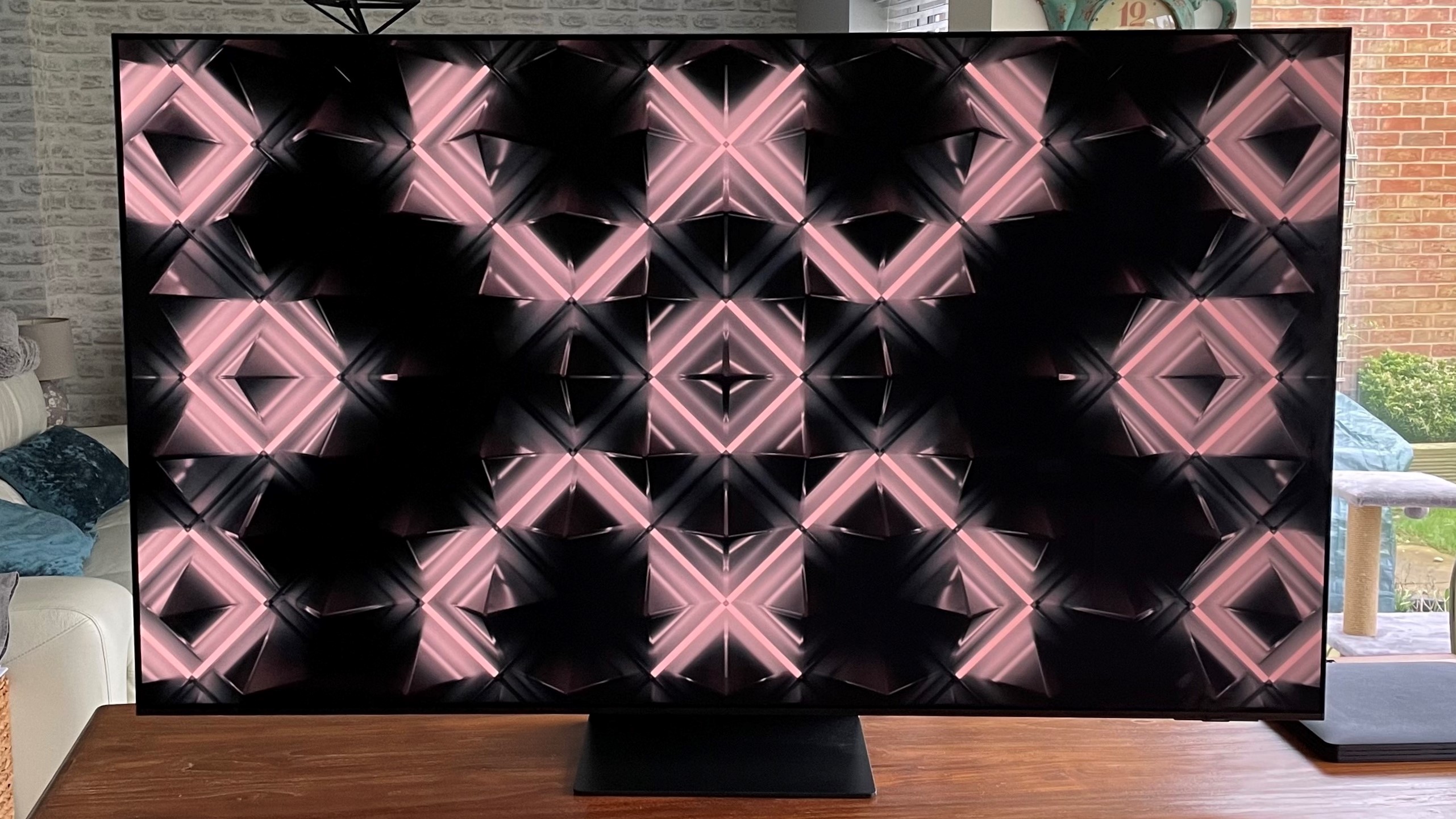 Samsung S95C OLED TV showing abstract image on wood table