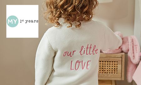 Baby wearing My 1st Years white sweater with our little love written on the back in pink