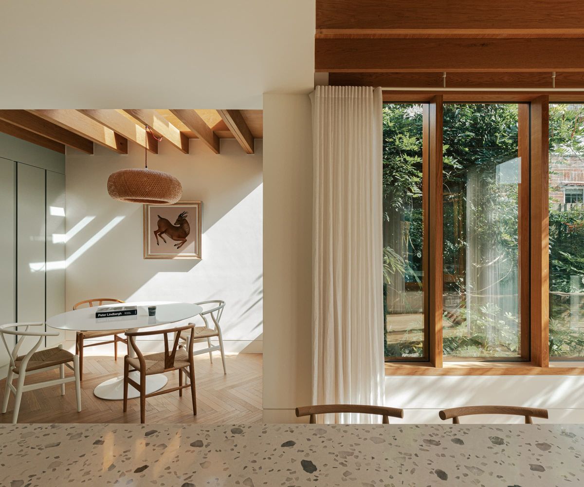 A kitchen dining area in a timber extension with a marble worktop and a small table