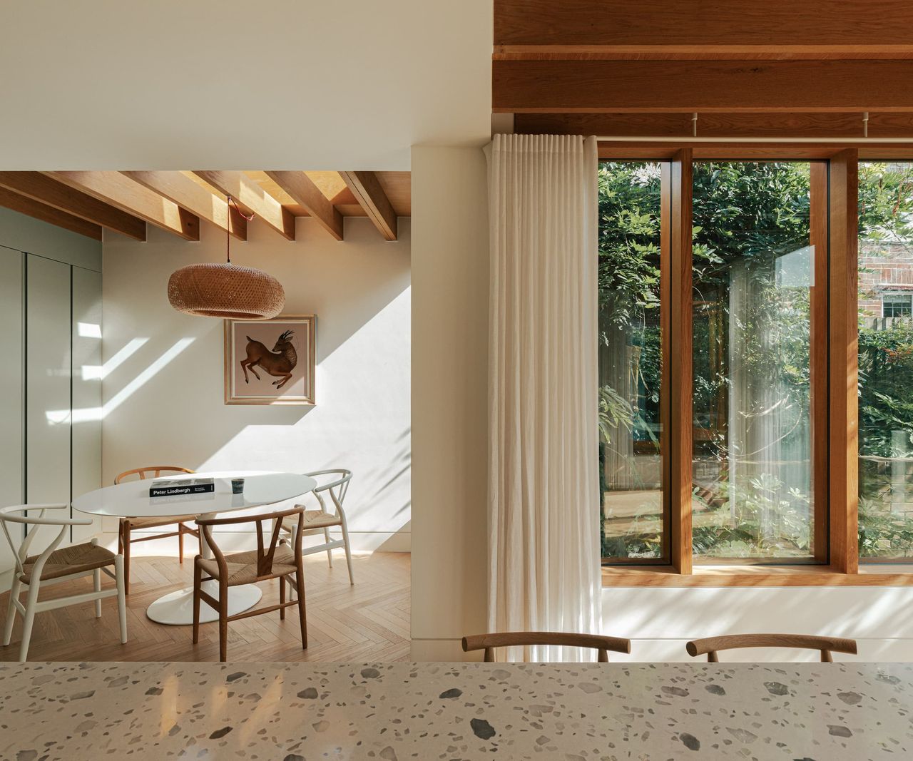 A kitchen dining area in a timber extension with a marble worktop and a small table