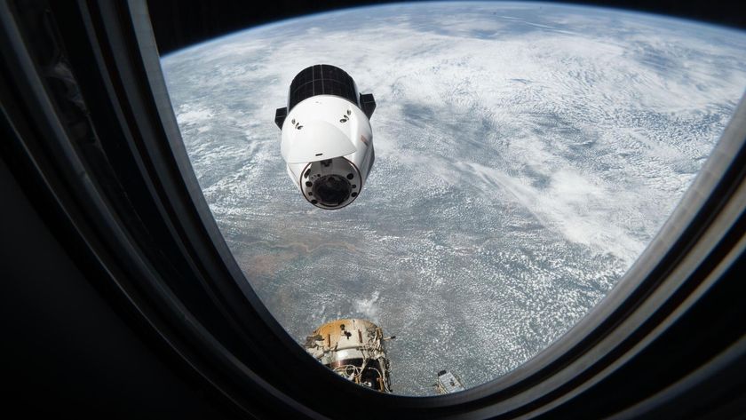 A white space capsule approaches the window where this photo is taken from as Earth floats in the background below