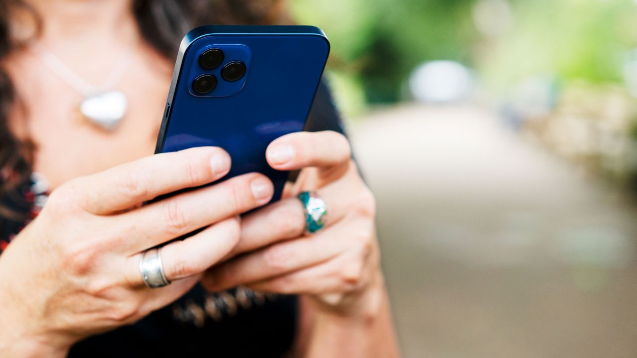 A woman holds a smart phone.