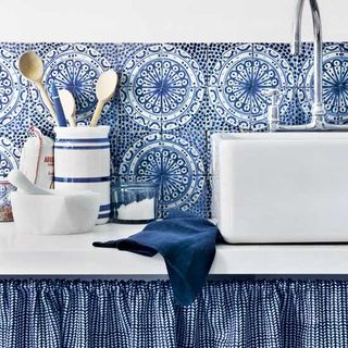 blue kitchen with bold splashback and patterned tiles