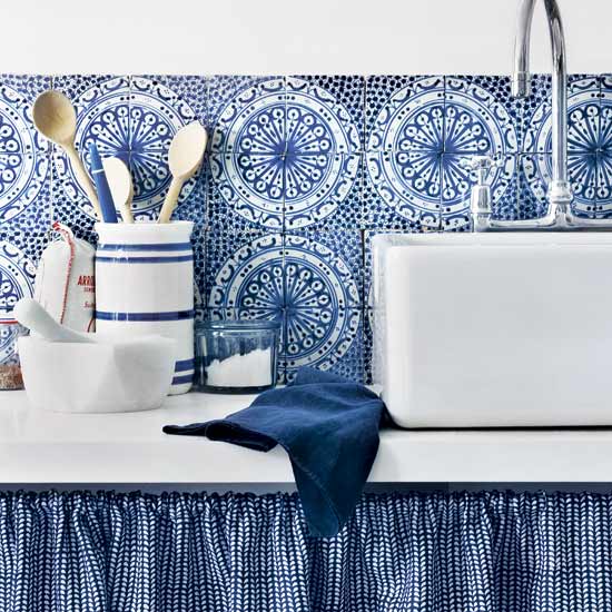 blue kitchen with bold splashback and patterned tiles