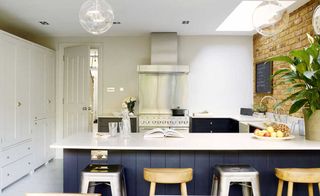 industrial style kitchen with mismatching bar stools and clear lightbulbs