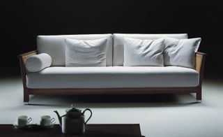 Wooden framed sofa with white cushions