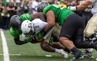 Quarterback Shedeur Sanders #2 of the Colorado Buffaloes is sacked by defensive end Jordan Burch and defensive lineman Taki Taimani #55 of the Oregon Ducks at Autzen Stadium on September 23, 2023