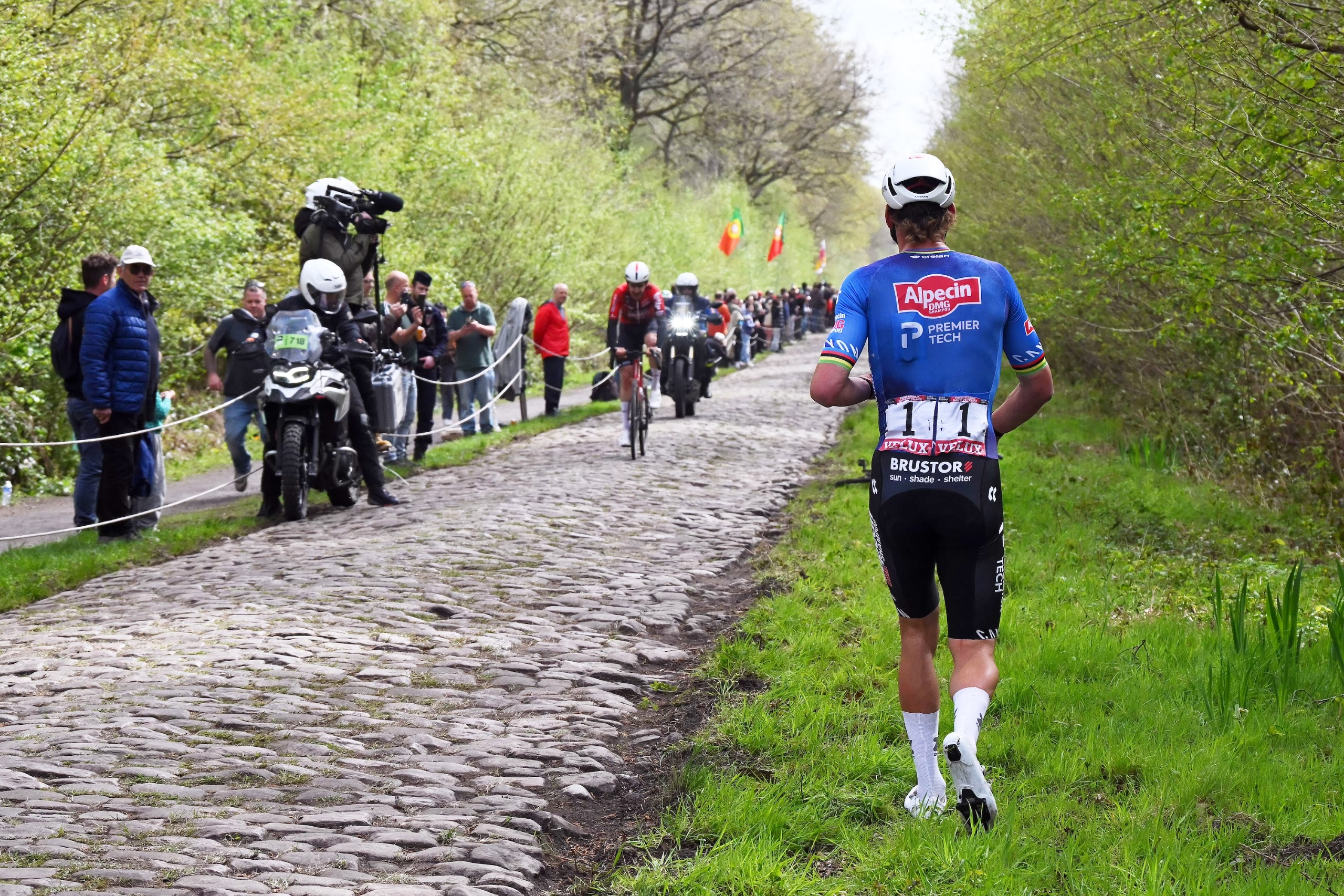 Mathieu van der Poel, in blue, walks along the Arenberg Trench at Paris-Roubaix