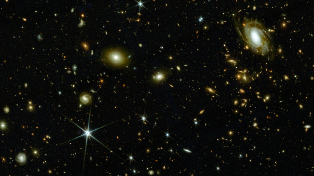 A bunch of spiral galaxies and bright blobs (also representing galaxies) on a dark section of sky.