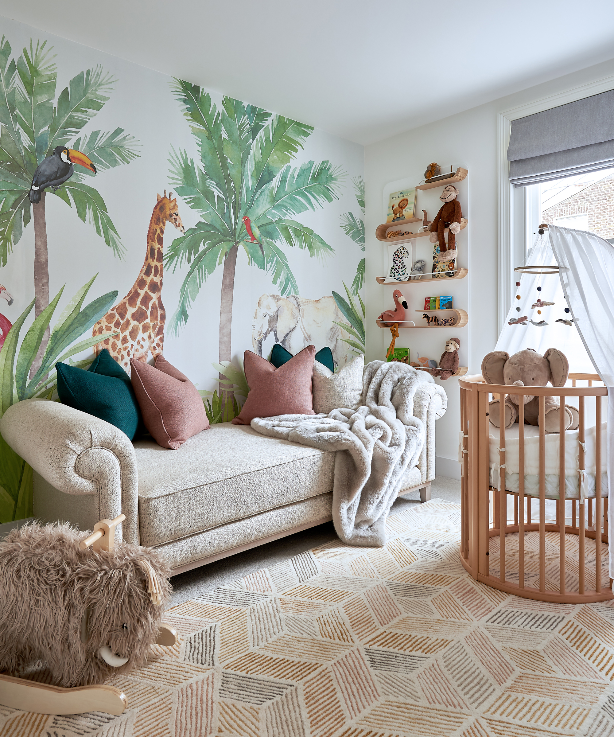 Baby boy nursery ideas with safari-inspired wall mural, wooden crib and taupe sofa.