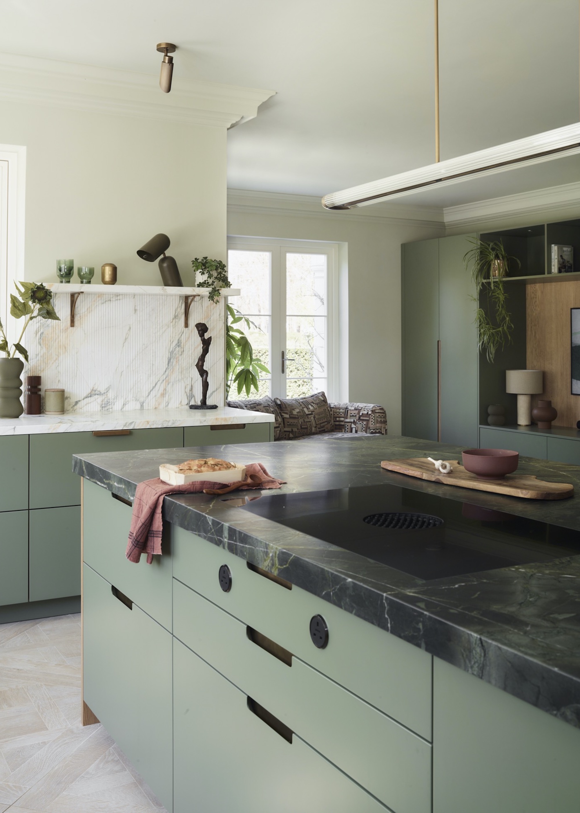 green kitchen with black induction hob on island
