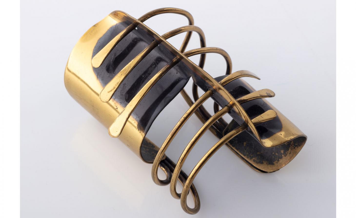 Brass spiral cuff against a grey background