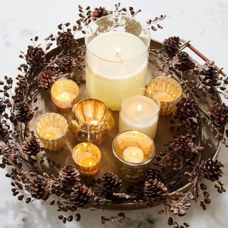 Glitter Pinecone Garland wrapped around a tray of candles.