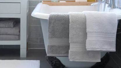Bath towels hanging off edge of bath