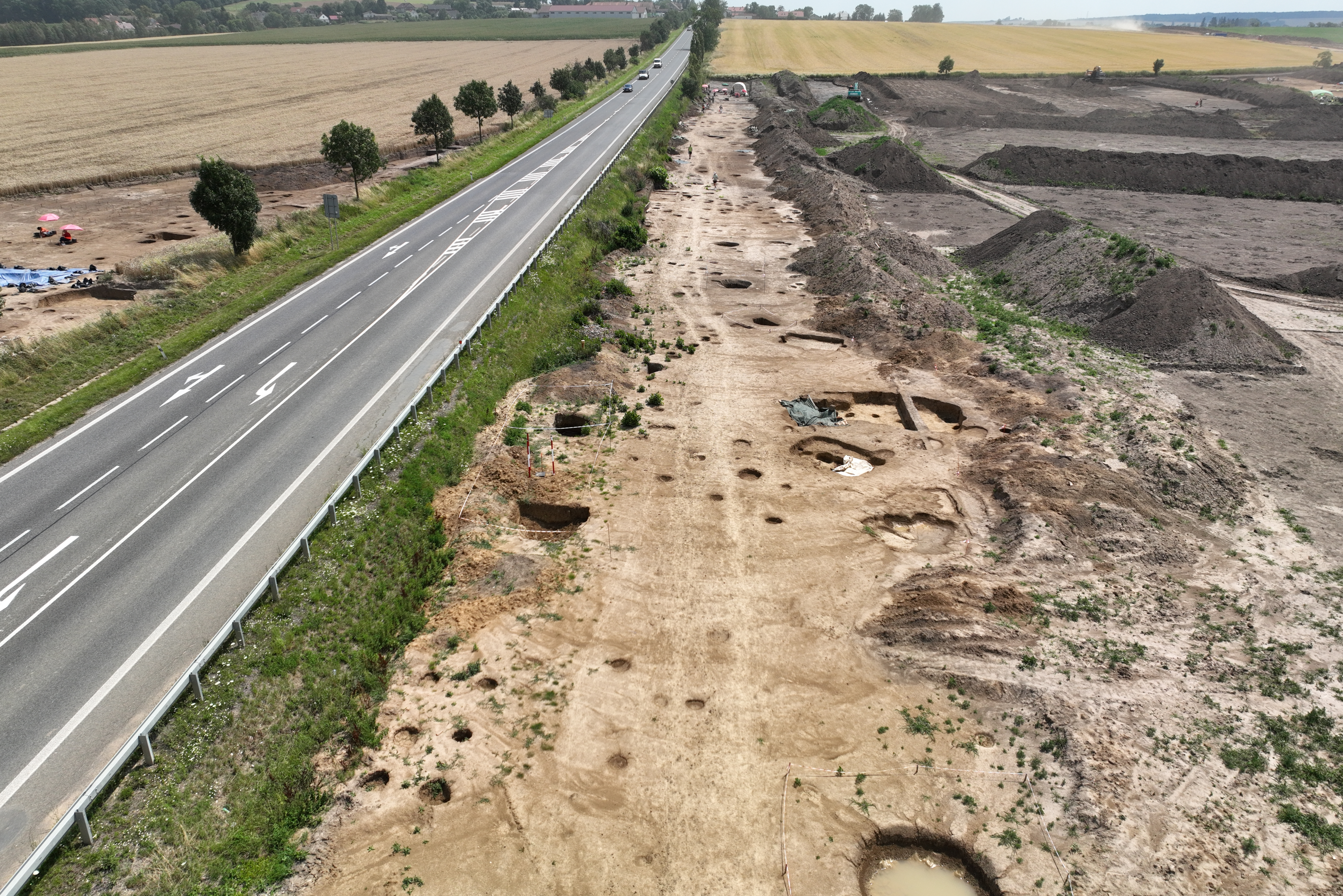 Archaeological excavation of celtic settlement; excavation photographed next to road.
