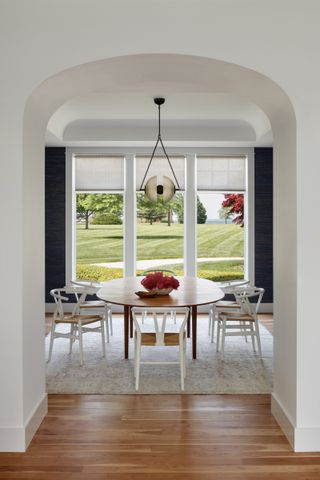 A dining room with dark walls and large windows