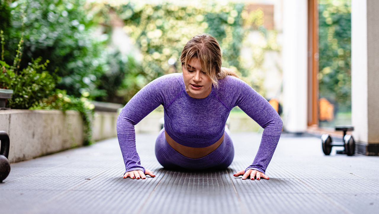 Woman performing push up outside