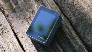 Akaso Brave 8 Lite action camera screen on a wooden surface outside