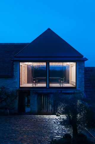 Exterior shot of Richard Parrs home studio at night showing lit up office space