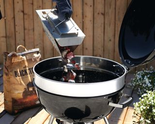 Chimney coal lighter with hot coals on a grill