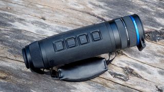 Pulsar Telos XQ35 monocular resting on a log outside