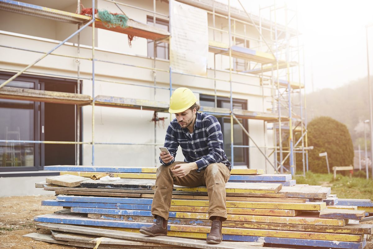 a builder on site looking at his phone