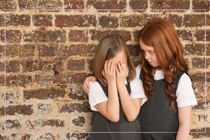 girl comforting her upset friend at school
