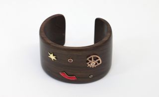 Wooden cuff design with studded with a blue diamond and slightly off-kilter yellow gold star