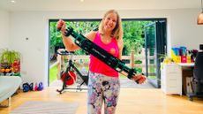 Smiling woman holds a thick belt with handles either end