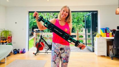 Smiling woman holds a thick belt with handles either end
