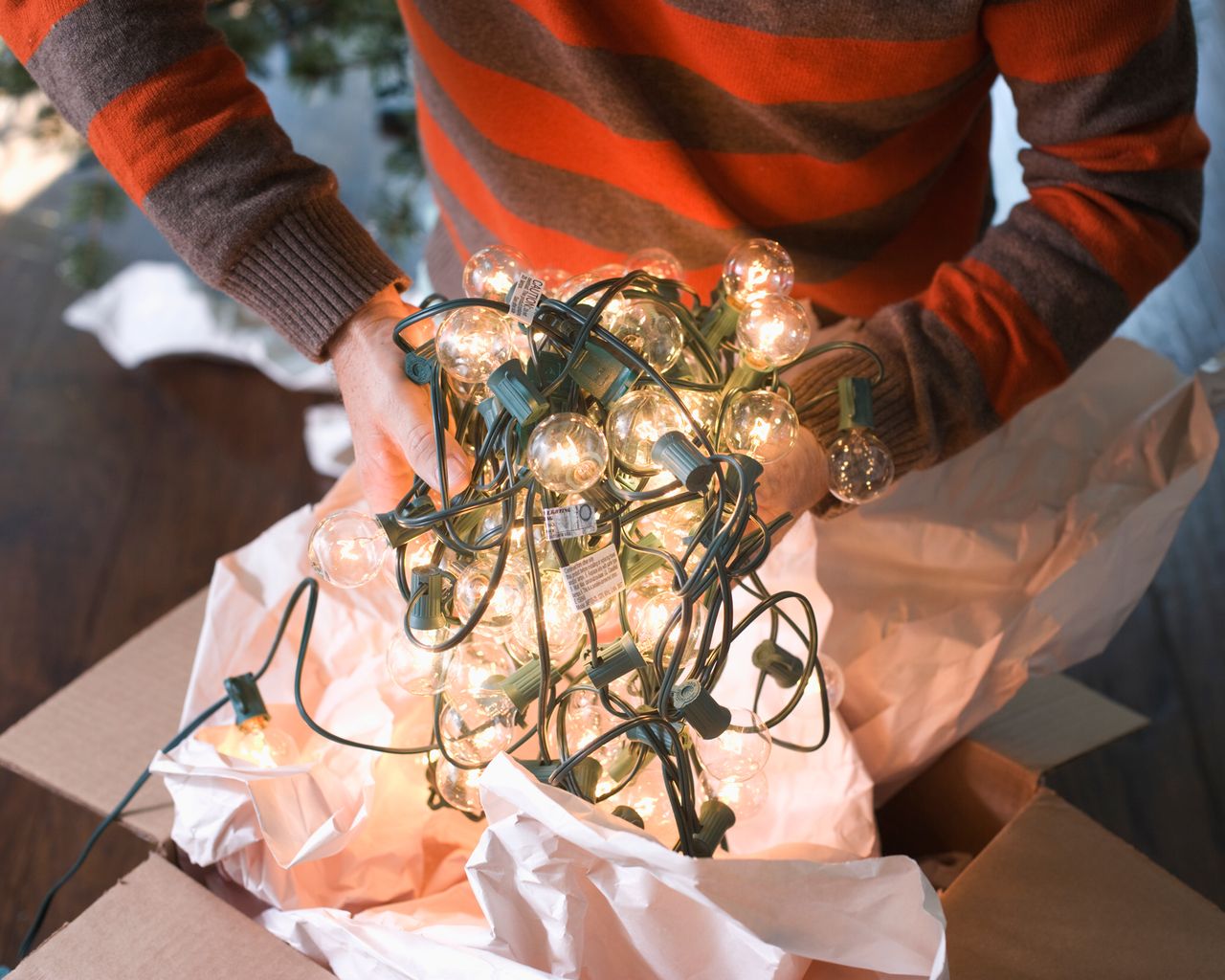 A man holding an interlocking string of Christmas lights