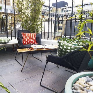 terrace with cushions on chairs and plants